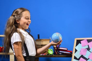 Kız küçük küre modeli ayakta blackboard tarafından tutar.