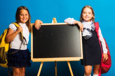 Mavi arka planda okul üniformalı kızlar