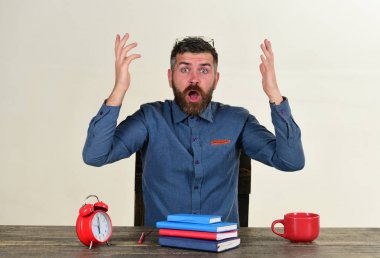 Adam şok yüzü ile tahta masada oturur