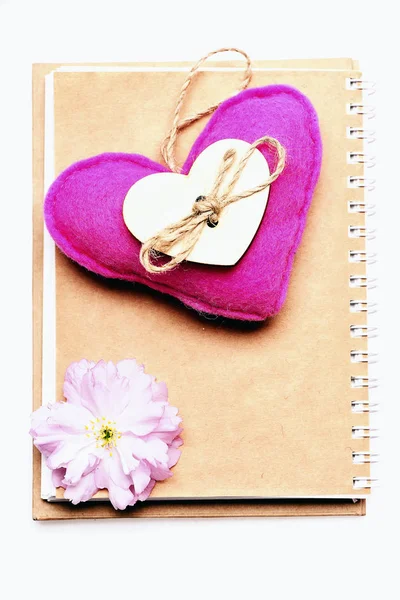 Kalp pembe renk ve pembe sakura çiçek not defteri üzerinde — Stok fotoğraf