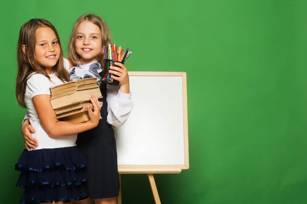 Mädchen in Schuluniformen stehen vor der Tafel — Stockfoto