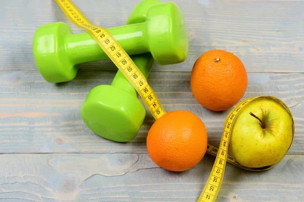 Weight loss concept, dumbbells weight with measuring tape, fruit — Stock Photo, Image