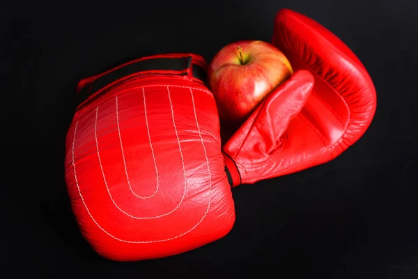 Guantes de boxeo con manzana aislada sobre fondo negro —  Fotos de Stock