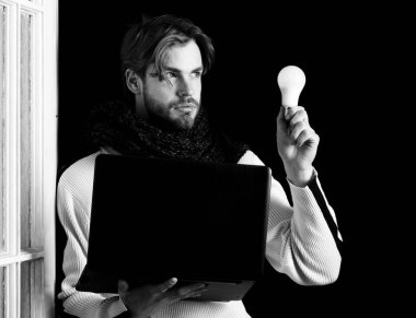 Laptoplu ve lambalı sakallı adam.