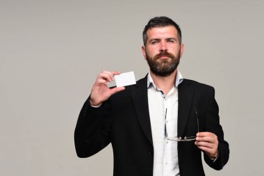 Sakallı takım elbiseli adam beyaz kartvizit tutar