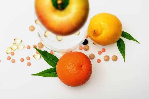 Olika frukter: citron, apelsin, äpple med vinglas, piller, kepsar — Stockfoto