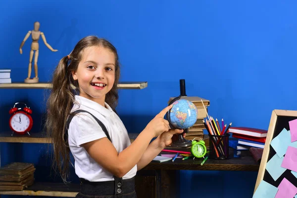 Estudante com sorriso detém e aponta para o globo — Fotografia de Stock