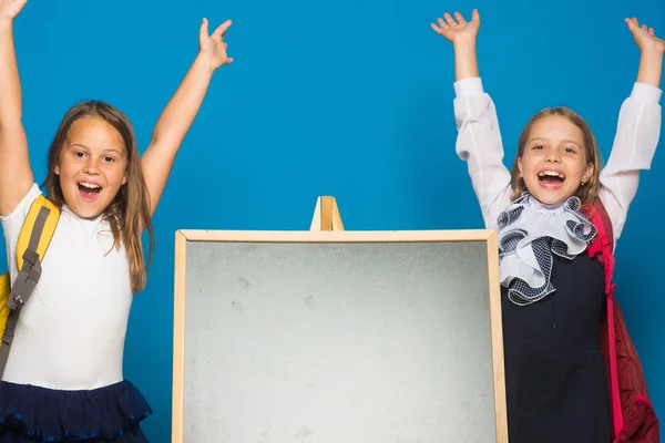 Schulmädchen mit glücklichen Gesichtern stehen neben Tafel — Stockfoto