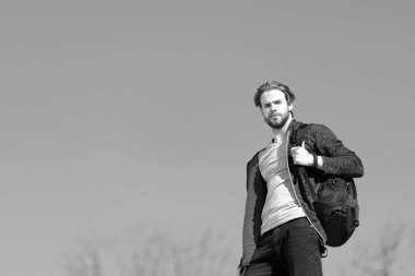 Spor çanta ile mavi gökyüzü arka plan karşı düşünceli genç adam