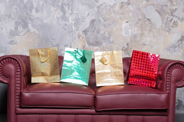 Canapé avec sacs cadeaux colorés — Photo