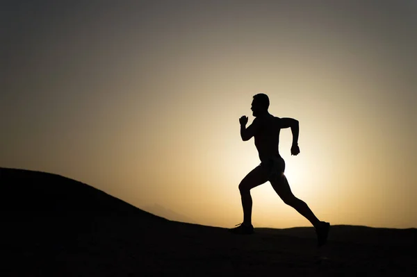 Running man silhouette at sunset sky — Stock Photo, Image