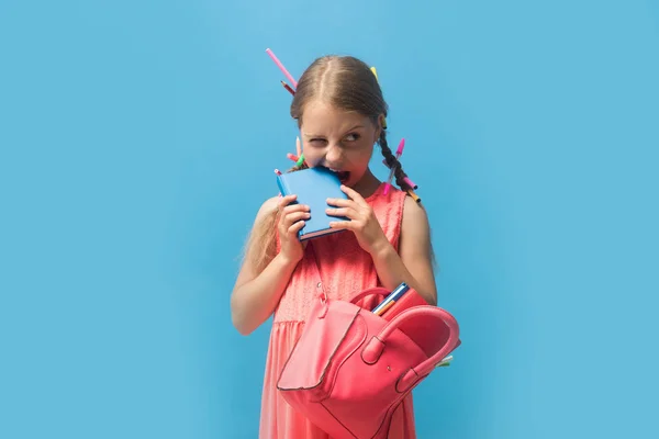 Kid with funny face expression and colored pencils in hair — Stock Photo, Image