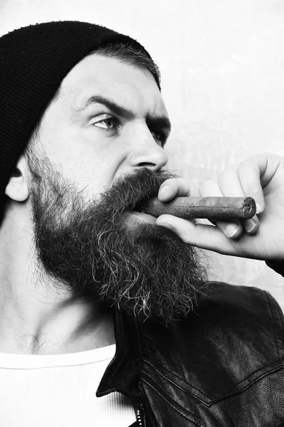 Бородатый кавказский хипстер курит сигару — стоковое фото