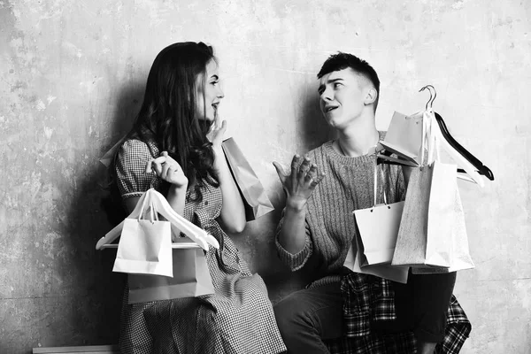 Feliz pareja de chica bonita y chico joven con paquetes — Foto de Stock