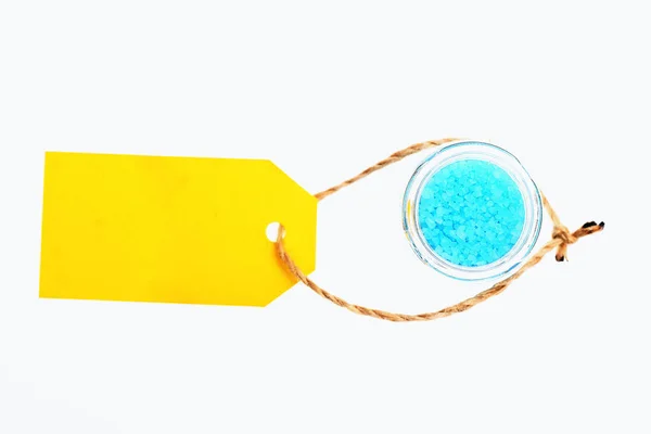 Modrá sůl v skleněné sklenice, žluté značce izolované na bílém — Stock fotografie