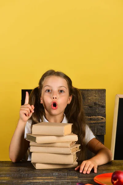 Girl sits on her wooden chair in classroom — Stock Photo, Image