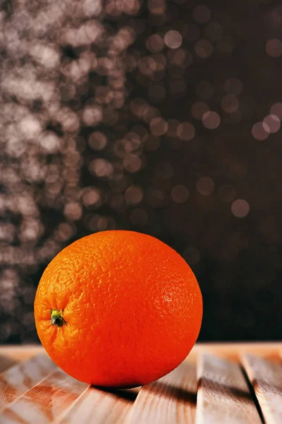 Laranja fresca na mesa de madeira marrom, fundo espumante — Fotografia de Stock