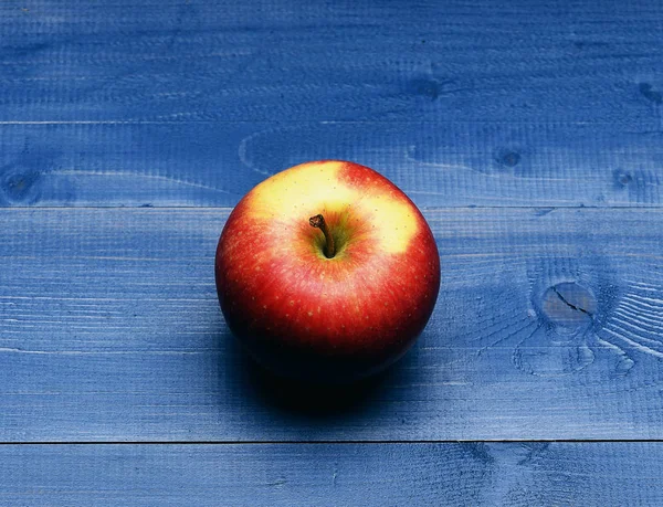 Червоне яблуко на старовинному фоні — стокове фото