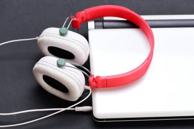 Bilgisayarla plastikten yapılmış kulaklık. Kulaklık ve gümüş dizüstü