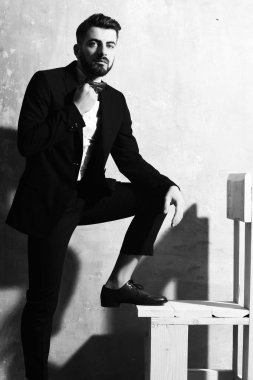 Stüdyo duvarında ciddi bir yüzü olan sakallı bir adam.