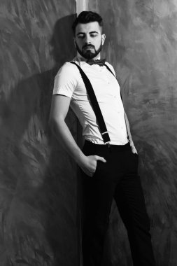 Stüdyo duvarında ciddi bir yüzü olan sakallı bir adam.