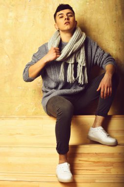 Gri süveter ve eşarplı yakışıklı genç adam.
