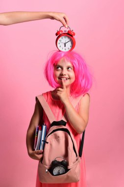 Pembe peruklu ve kırmızı alarmlı okul üniformalı öğrenci.