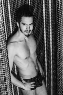 Yakışıklı kaslı seksi adam duşta yıkanıyor.