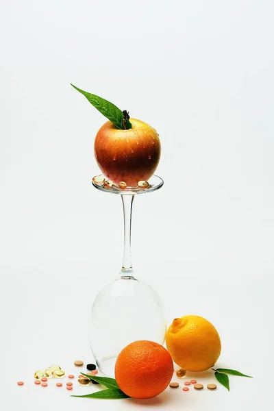 Apelsin, äpple och citron, vinglas med piller och kapsel — Stockfoto
