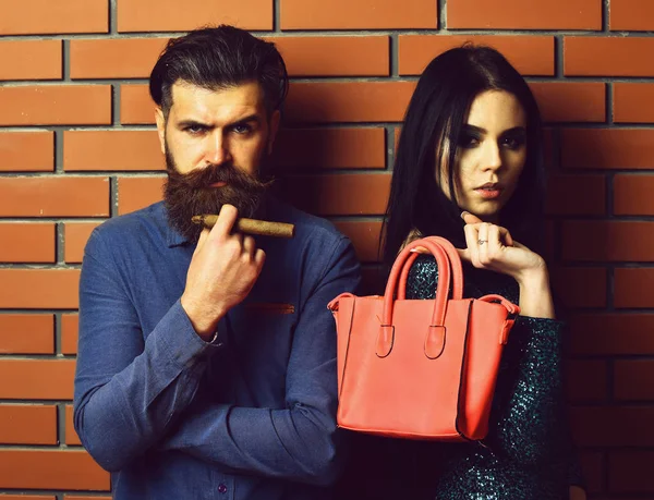 Бородатый мужчина и довольно сексуальная женщина с сумкой и сигарой — стоковое фото