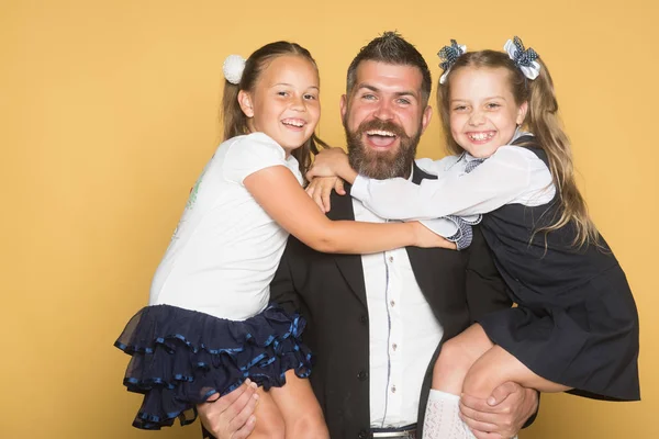 Colegialas con caras sonrientes abrazo hombre con barba — Foto de Stock