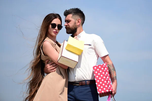 Couple carries colorful packets and box on blue background — Stock Photo, Image