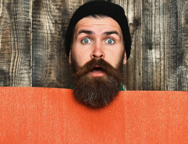 Bearded brutal caucasian hipster with red paper sheet — Stock Photo, Image