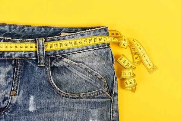 Primer plano de jeans con cinta métrica: concepto de estilo de vida saludable — Foto de Stock