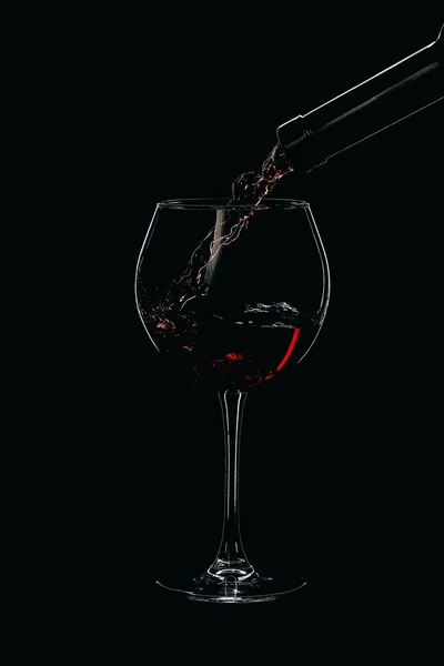 Bicchiere da vino e bottiglia con vino isolato su sfondo nero — Foto Stock