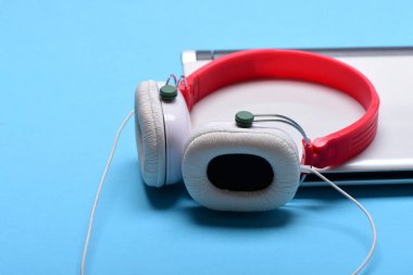 Müzik ve dijital ekipman kavramı. Kulaklık ve gümüş dizüstü.