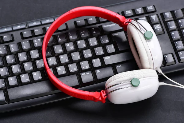 Electronic appliances on black background. Earphones in red and white