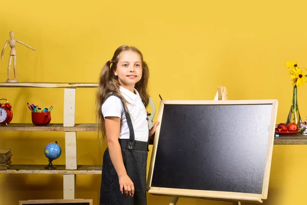 Sarı duvar arka plan üzerinde çocuk ve okul malzemeleri