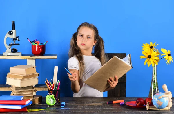 Κορίτσι με σοβαρό πρόσωπο κρατά το μολύβι και το βιβλίο — Φωτογραφία Αρχείου
