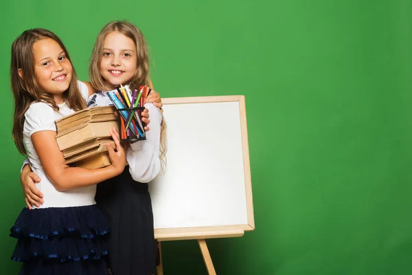 Mädchen in Schuluniform vor der Tafel — Stockfoto