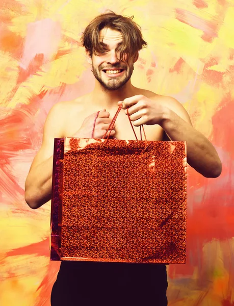 Caucásico barbudo sexy macho hombre celebración rojo paquete o bolsa — Foto de Stock