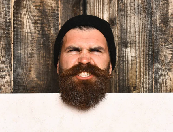 Bearded brutal caucasian hipster with white paper sheet — Stock Photo, Image