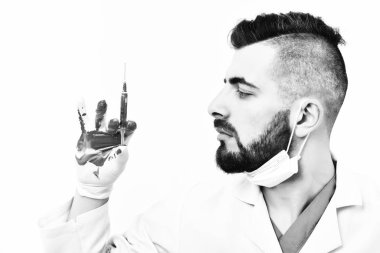 Tıbbi üniformalı sakallı şırınga tutar