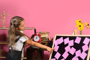 Çocuk ve okul malzemeleri, pembe bir arka plan. Çocukluk ve çalışma zamanı