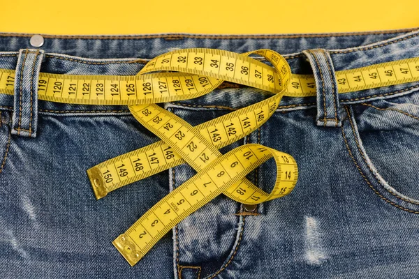 Oberteil der Jeans mit gelbem Maßband als Gürtel — Stockfoto