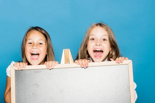 Schülerinnen mit überraschten Gesichtern stehen hinter Tafel — Stockfoto