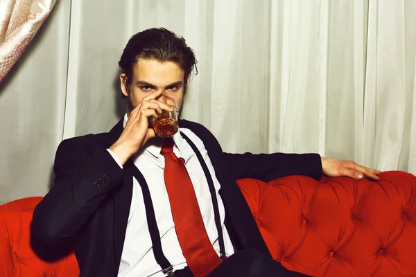 Vousatý muž, obchodník se sklenicí whisky v červené kravatě — Stock fotografie