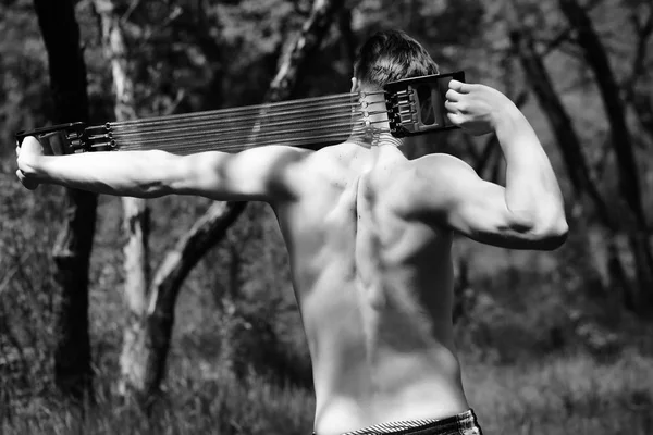 Сильный спортсмен с профессиональным экспандером показывает свою спину мускулами — стоковое фото
