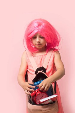 Okula dönmek ve öğrenme konsepti. Çalar saati olan çocuk