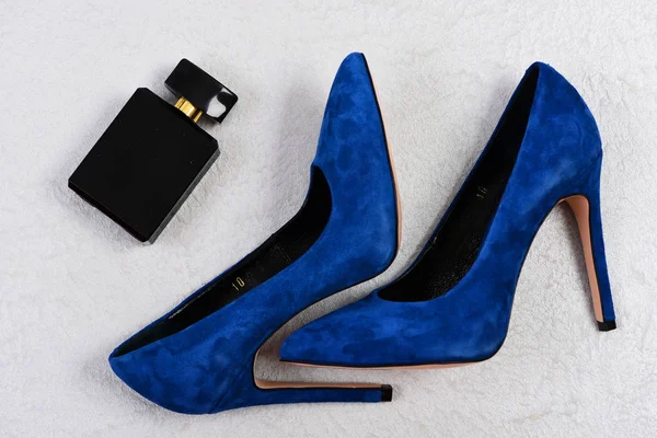Vrouwelijke schoenen in donker blauwe kleur en zwarte parfumfles — Stockfoto